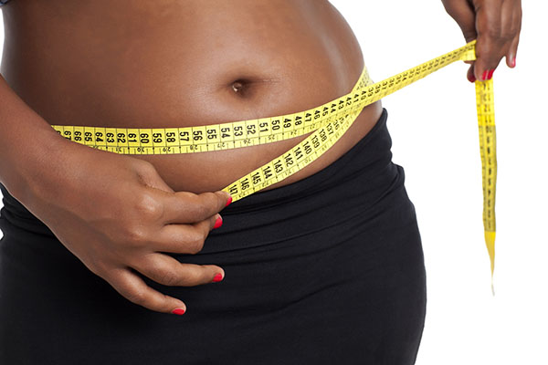 Weight loss, waist and tape measure of a black woman in studio for a slim  body